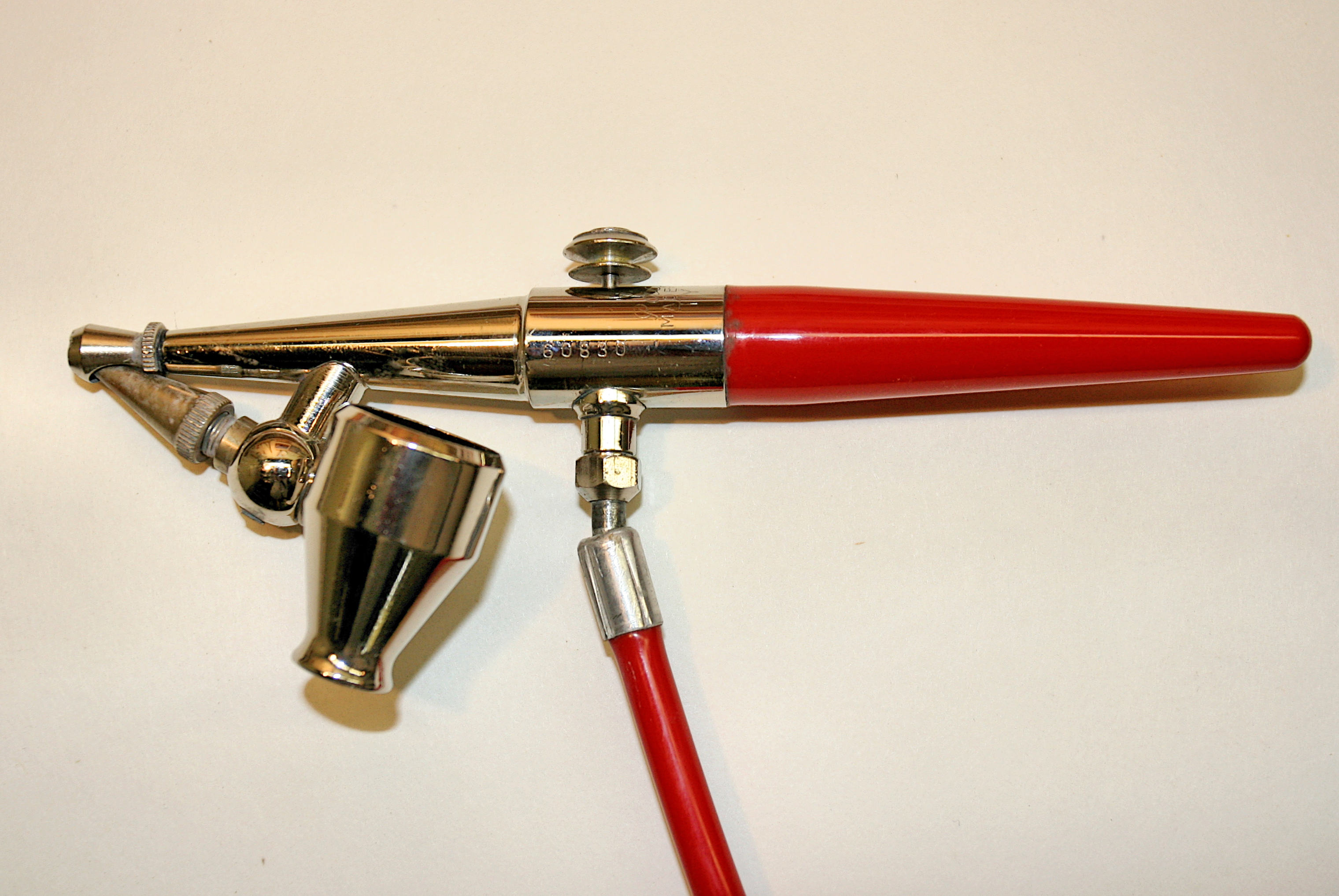 Silver and red airbrush on a light background.