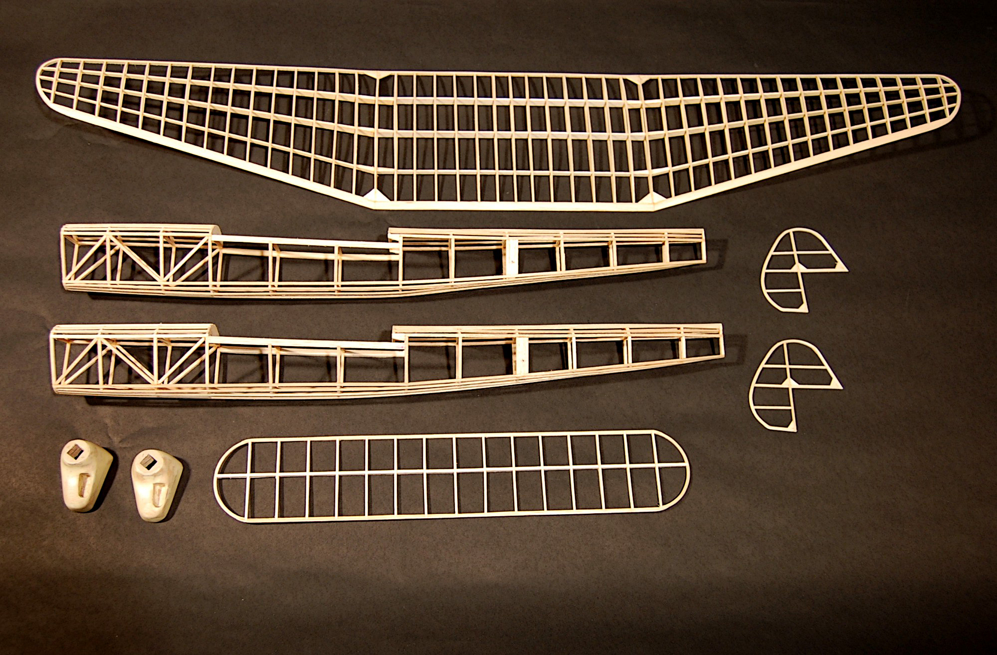 Model airplane frame parts on a dark surface.
