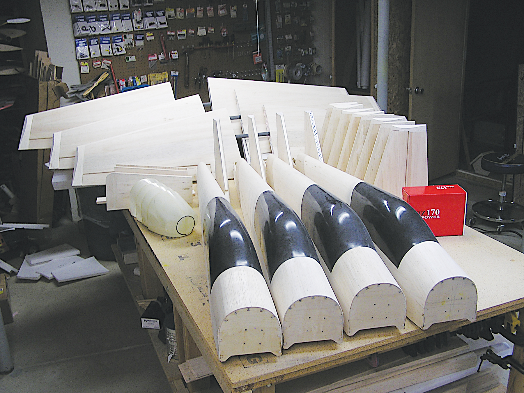 Wood airplane model parts arranged on a workshop table.
