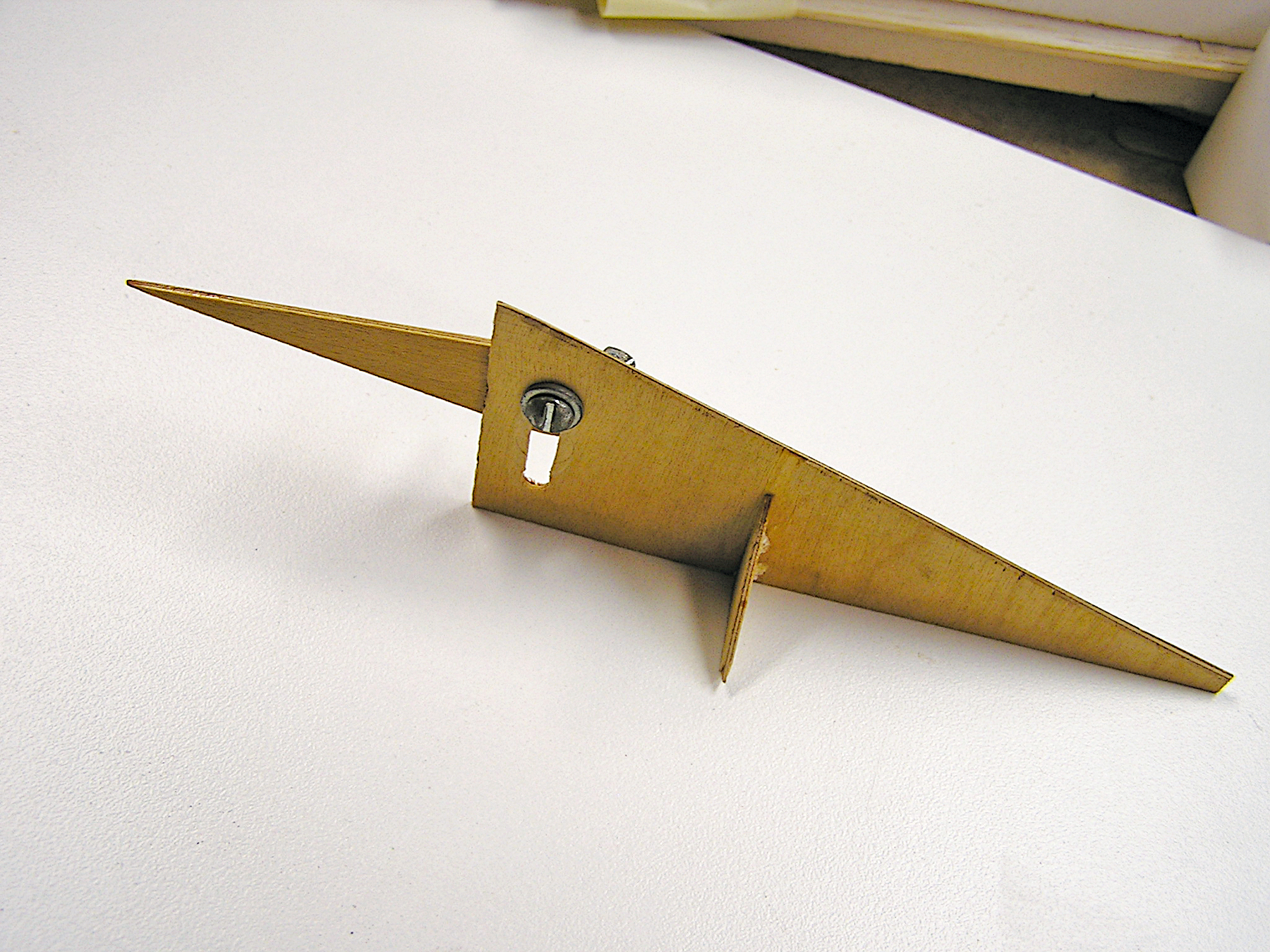 Wooden truss jig resting on a white surface.