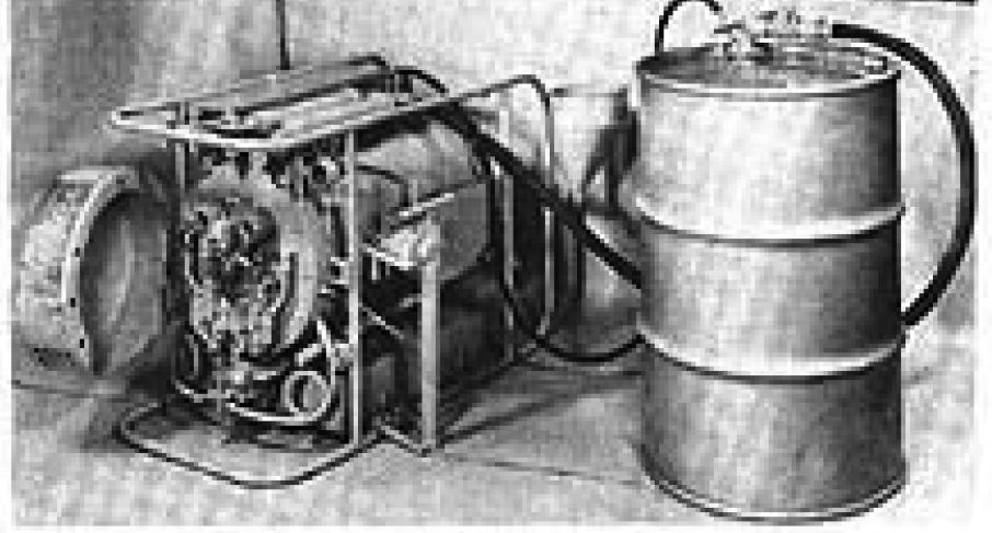 Vintage machinery with attached metal drum and hoses. Black and white photograph.