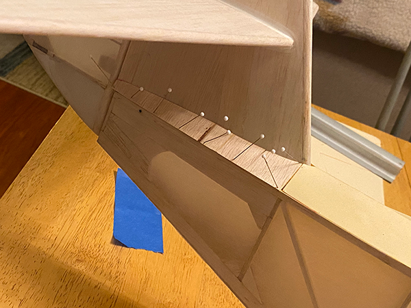 Model airplane tail section on a wooden table.