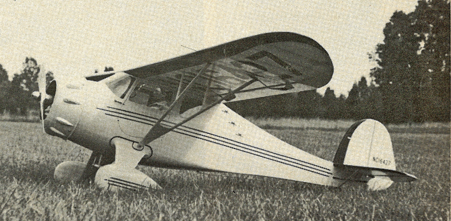 Vintage airplane on grassy field, black and white photo.
