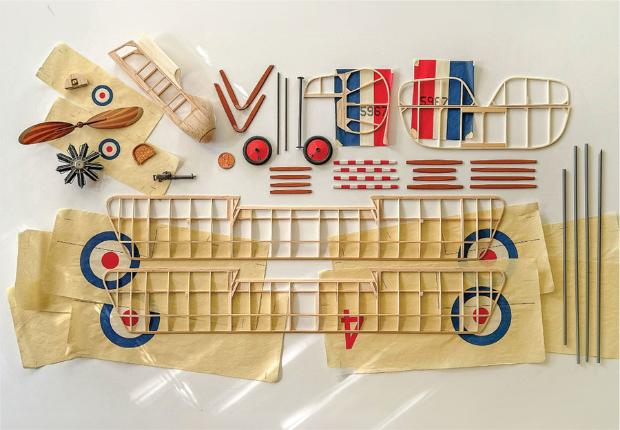Model airplane kit parts laid out on a white surface.