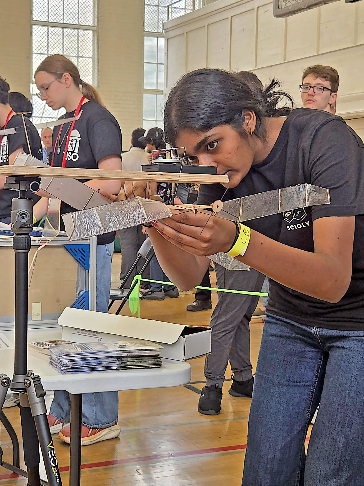 Woman adjusts a small glider in a gymnasium setting.