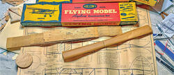 Wooden model airplane kit with plans and ruler.