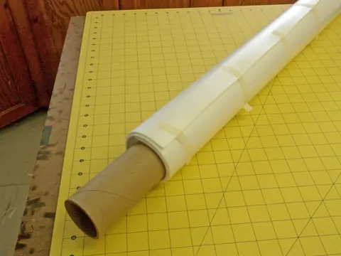 Roll of vinyl on a large cutting mat with grid lines.