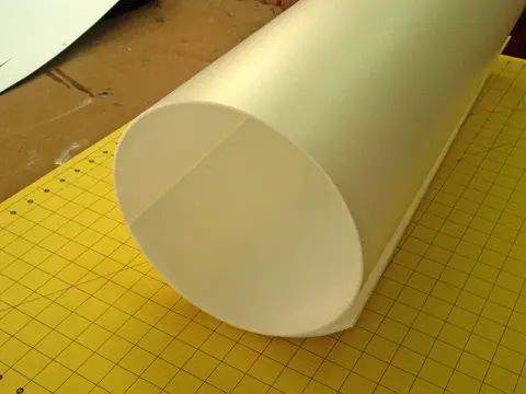 Large white paper tube on a yellow grid mat.