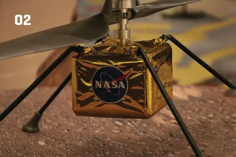 NASA Mars helicopter prototype with a gold body, labeled "02."