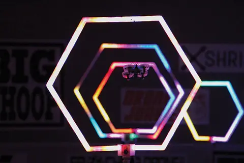 Hexagonal neon lights in rainbow colors on a dark background.