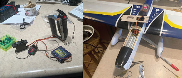 Remote control parts on a table; model aircraft with blue and yellow wings.