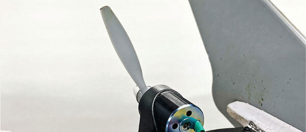 Small propeller with motor attached to a white surface.
