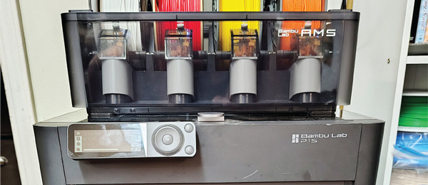 3D printer with four resin tanks and digital control panel.