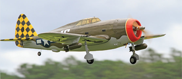 WWII-era fighter plane with checkered tail in flight.