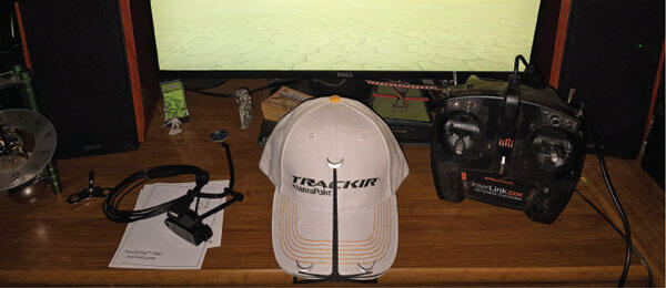 Cap with "Team Pimps" text, surrounded by electronics on a wooden desk.