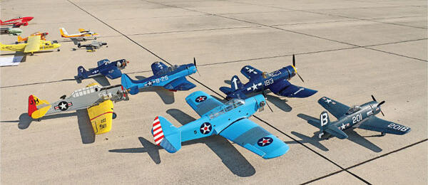 Colorful model planes on a concrete surface, including blue and yellow ones.