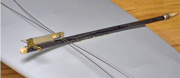 Black slingshot style catapult on a gray surface.