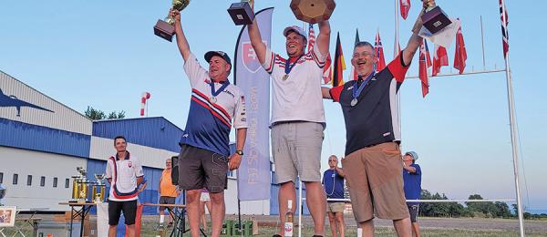 Neal proudly holds the silver trophy aloft
