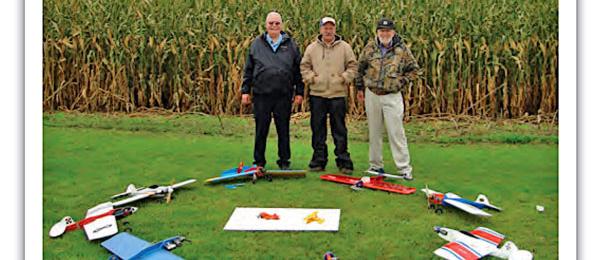 a group of people standing on top of a grass covered field