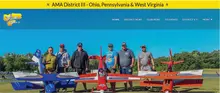 Group of men standing with model planes, AMA District III banner above.