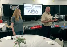 Two people speaking in front of an AMA Foundation screen in a conference room.