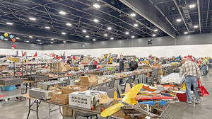 Model planes displayed on tables in a spacious indoor event hall.